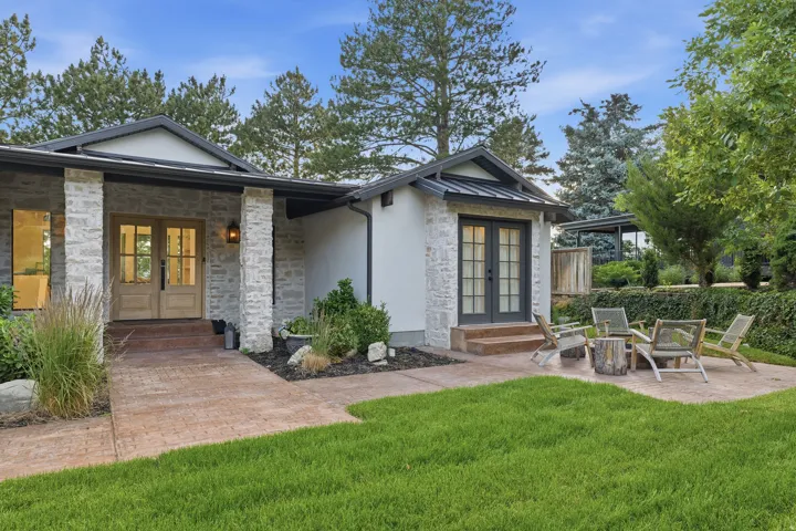 Stone facade exterior featuring a covered entry with double wooden doors