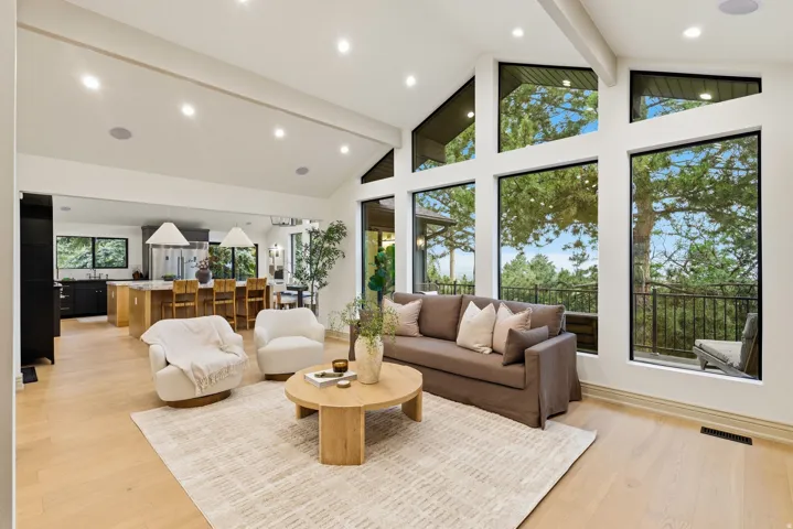 Vaulted ceilings with exposed beams complement the light wood-finish flooring
