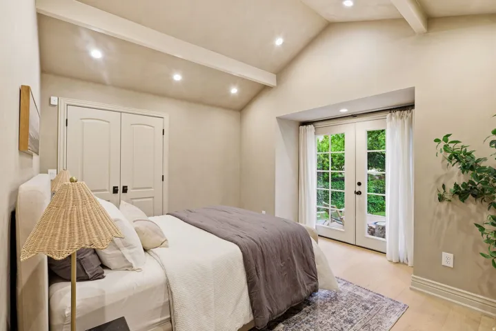 Vaulted ceiling with exposed beams and recessed lighting