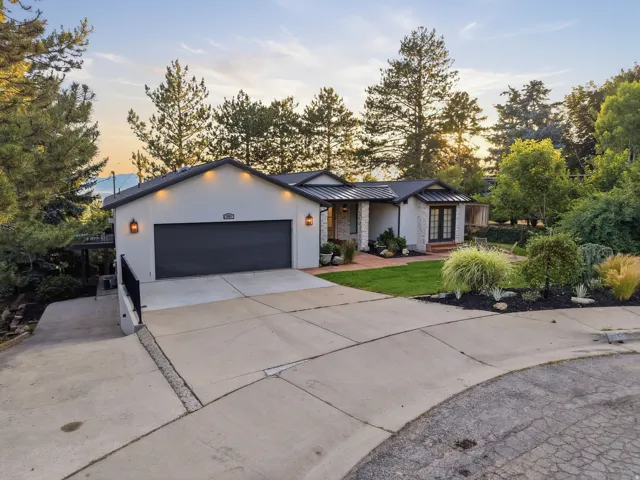 Contemporary stucco exterior with a dark garage door and accent lighting