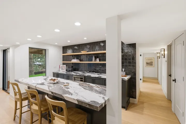 Expansive kitchen island featuring a waterfall edge and natural stone countertop