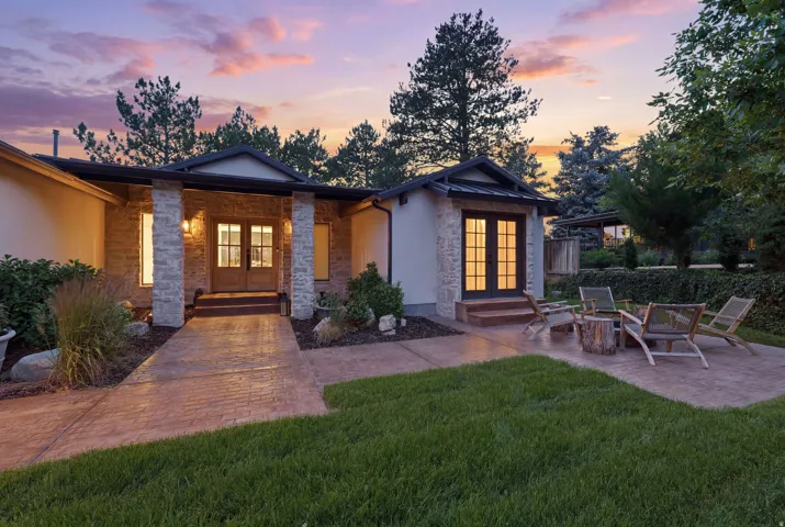 Exterior featuring a stone facade, a stamped concrete walkway, and a covered entry with dual glass-paneled doors