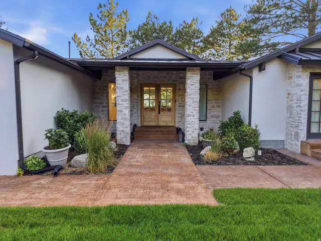 Stucco and stone facade featuring a stamped concrete walkway