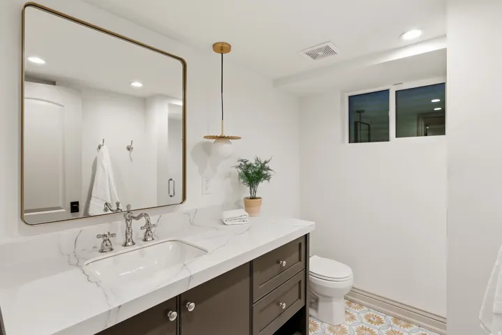 Bathroom featuring a dark wood-finish vanity with a white countertop and an undermount sink