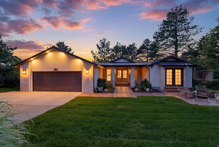 Stucco exterior with stone accents and a dark metal roof
