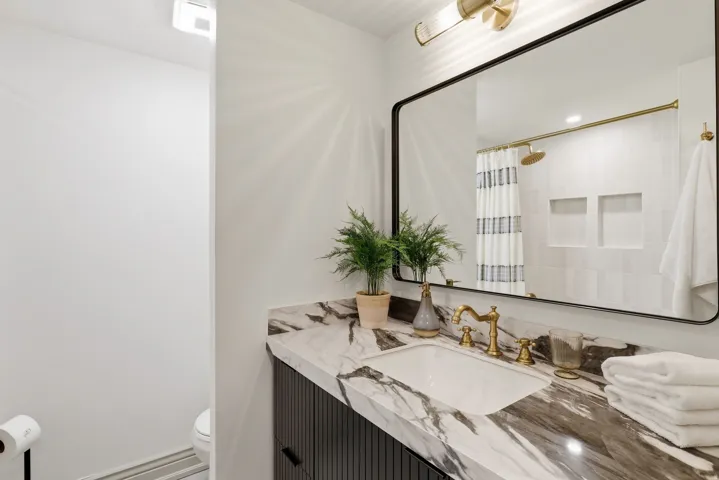 Bathroom vanity featuring a rectangular undermount sink and a marbled countertop