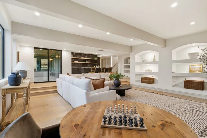 Spacious living area featuring light wood-finish flooring and recessed lighting
