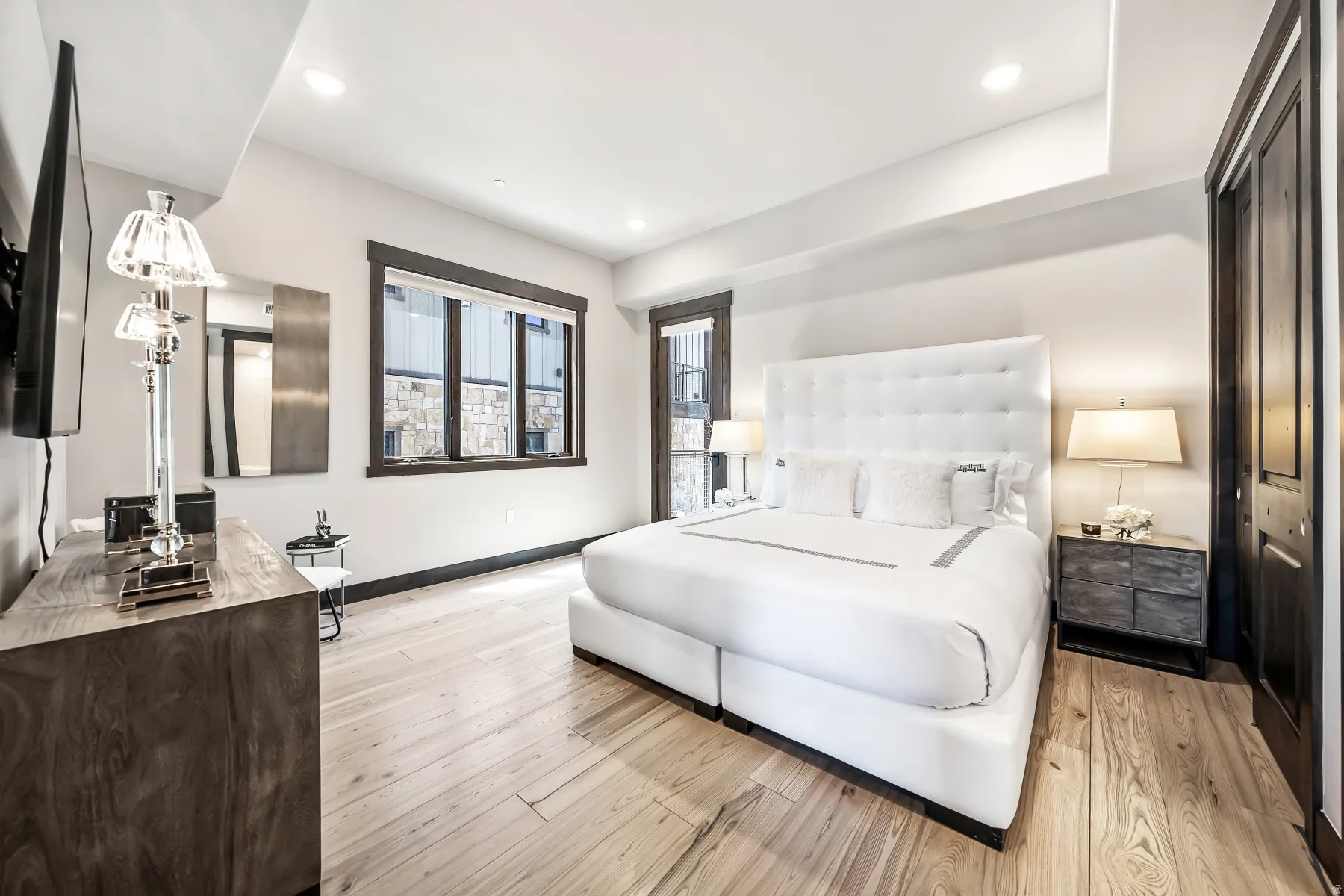 Spacious room featuring light wood-finish flooring and recessed ceiling lighting
