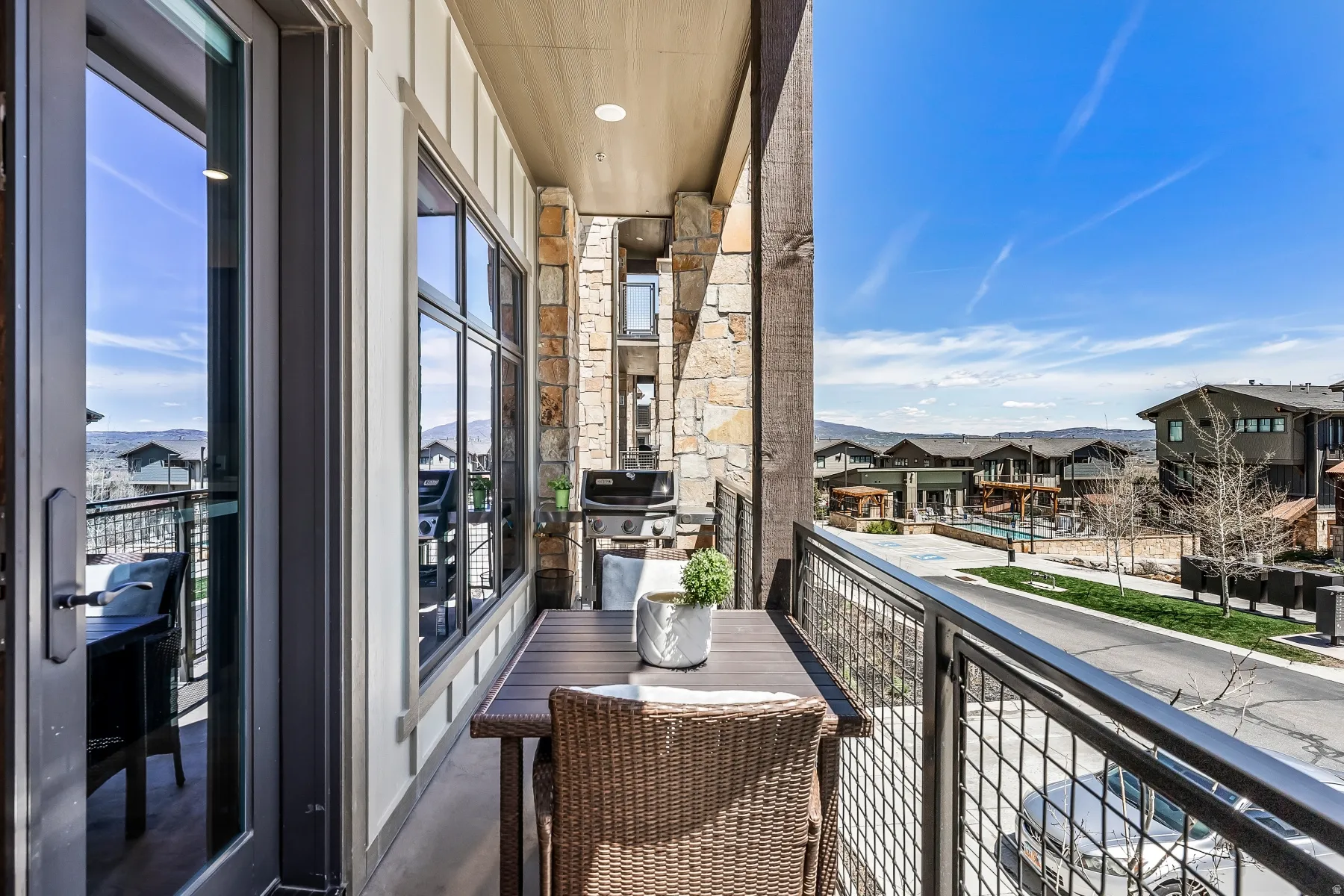 Balcony featuring stone and vertical siding accents
