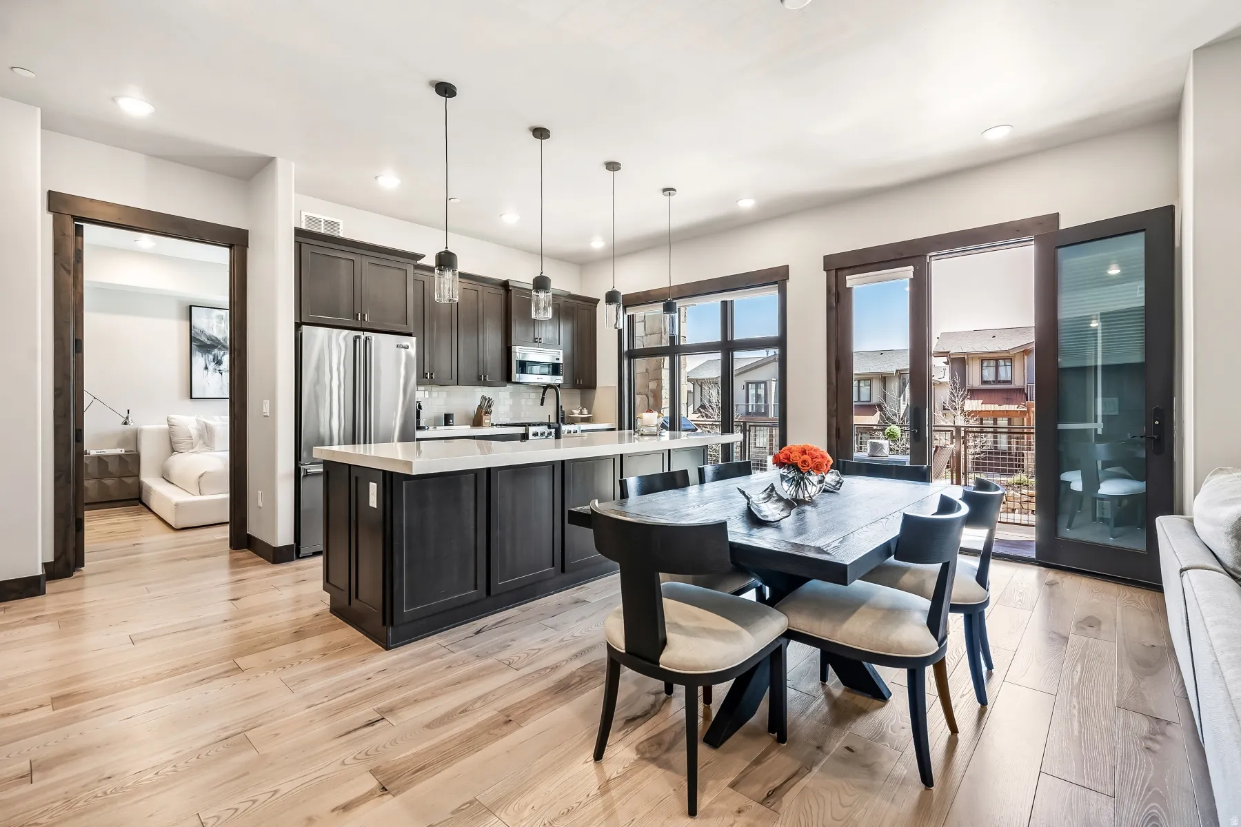 Open-concept living area featuring light wood-finish flooring, recessed lighting, and dark wood trim