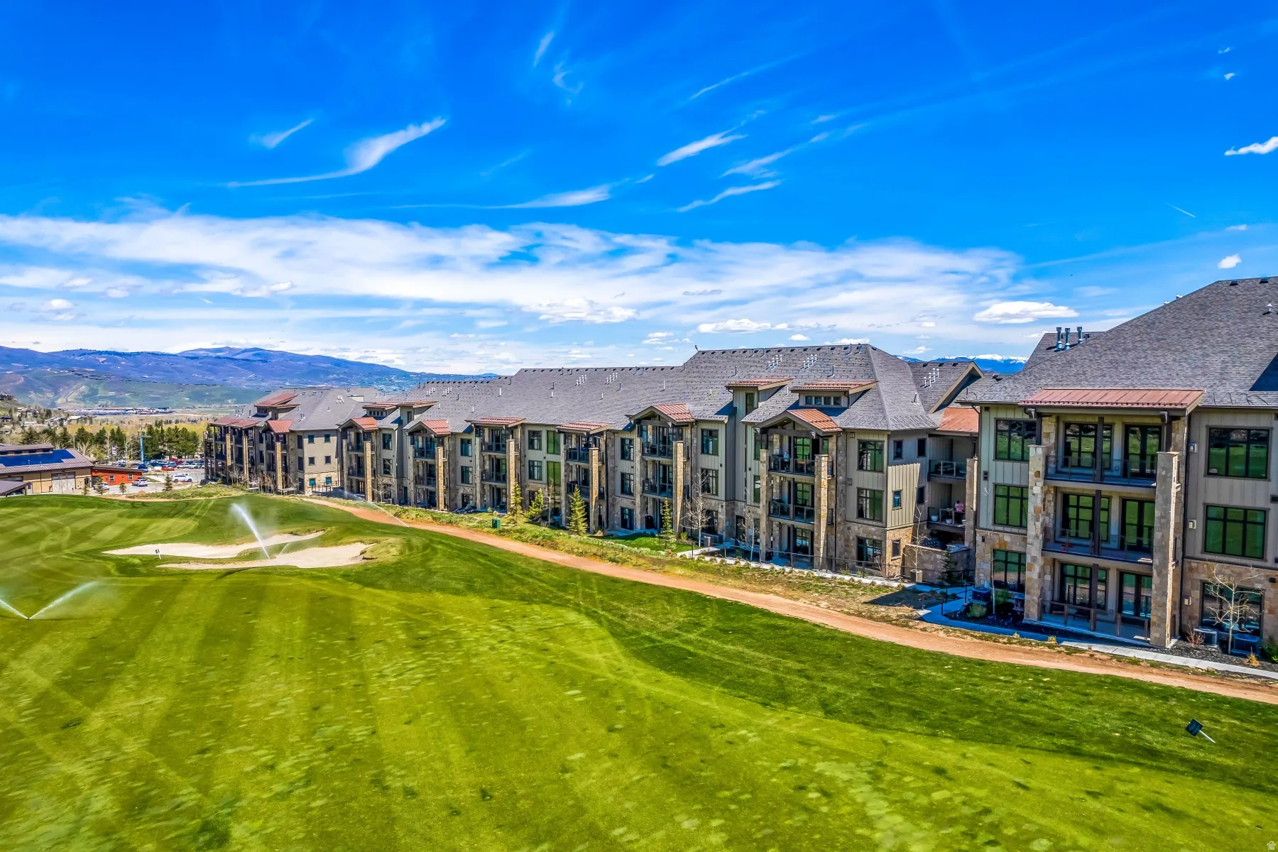 Multi-story residences featuring stone and wood siding, multiple balconies, and gabled roofs