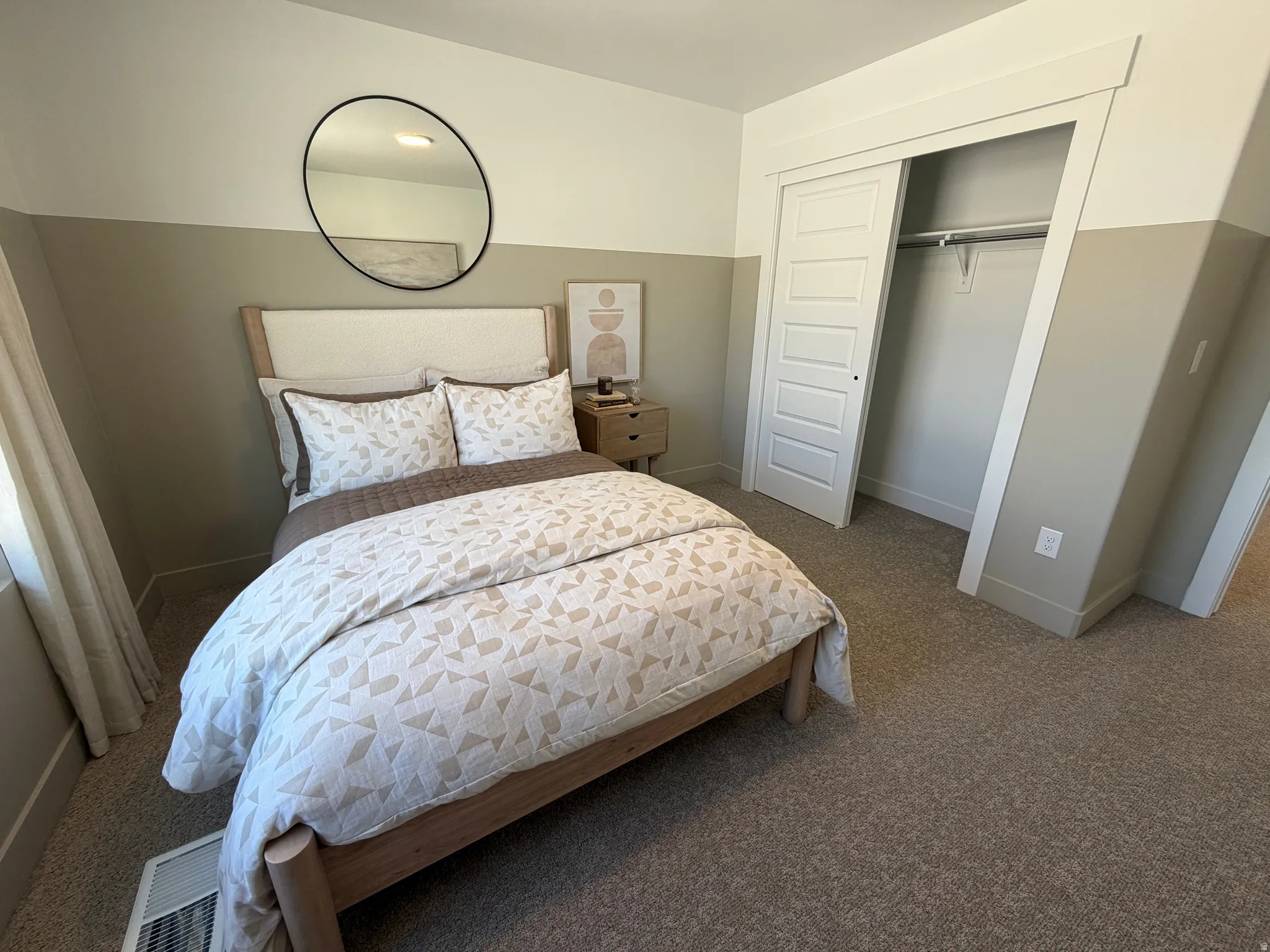 Bedroom featuring two-tone painted walls, carpeted flooring, and a window with natural light
