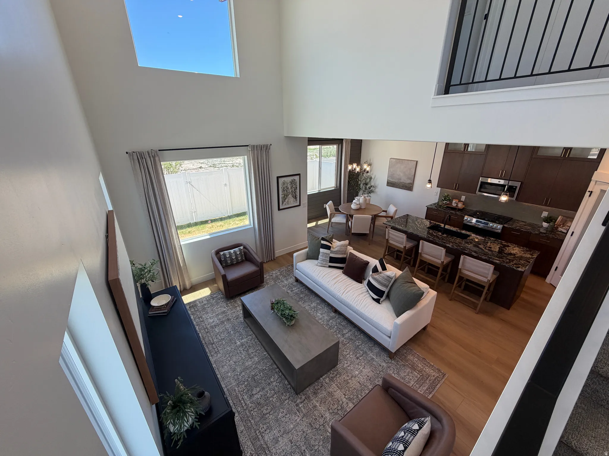 Open-concept living space featuring high ceilings, a prominent skylight, and wood-finish flooring
