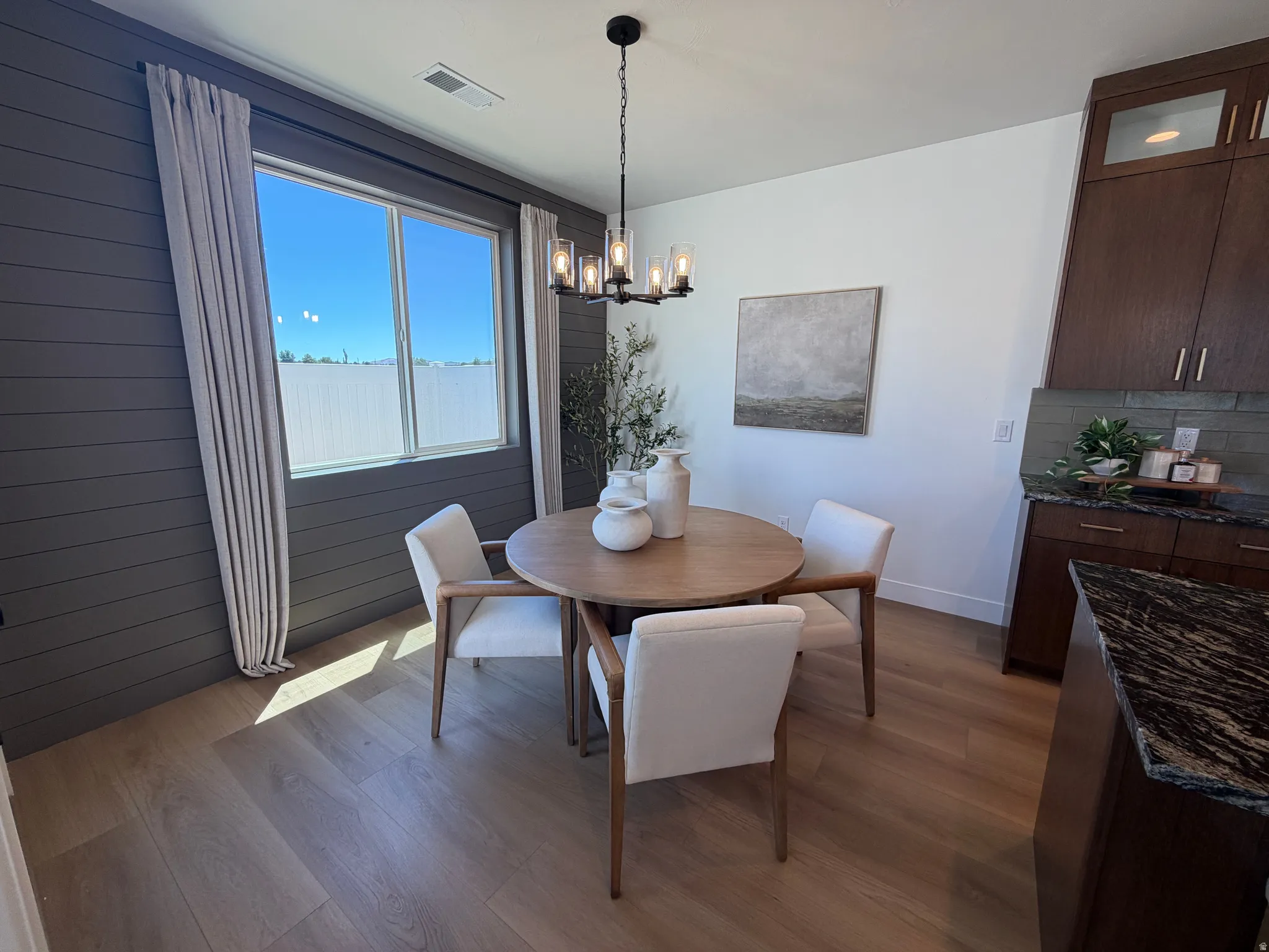 Dining area featuring wood-finish flooring and a contemporary chandelier