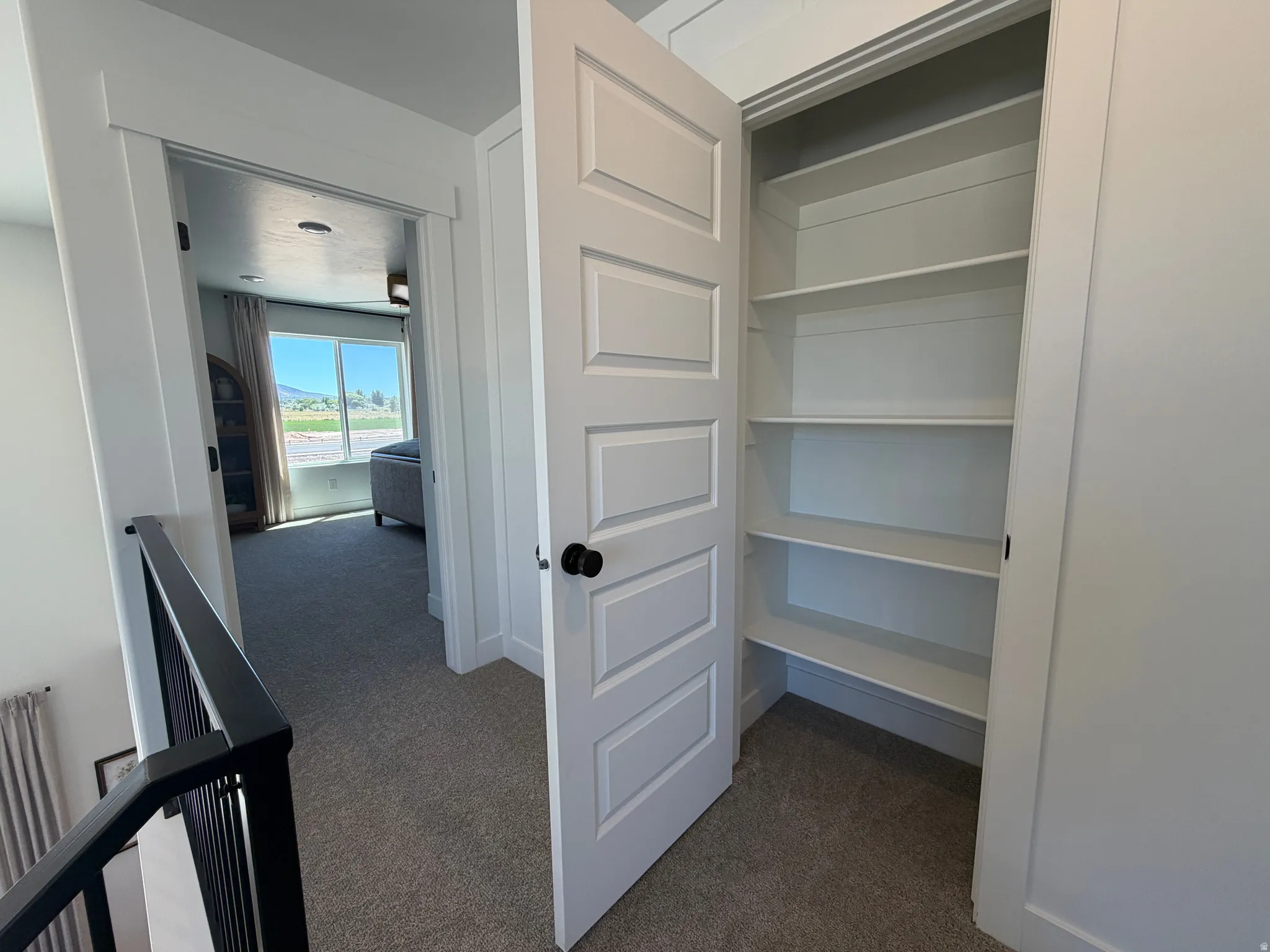 Hallway storage closet with multiple built-in shelves