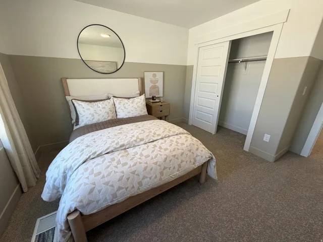 Bedroom featuring two-tone painted walls, carpeted flooring, and a window with natural light