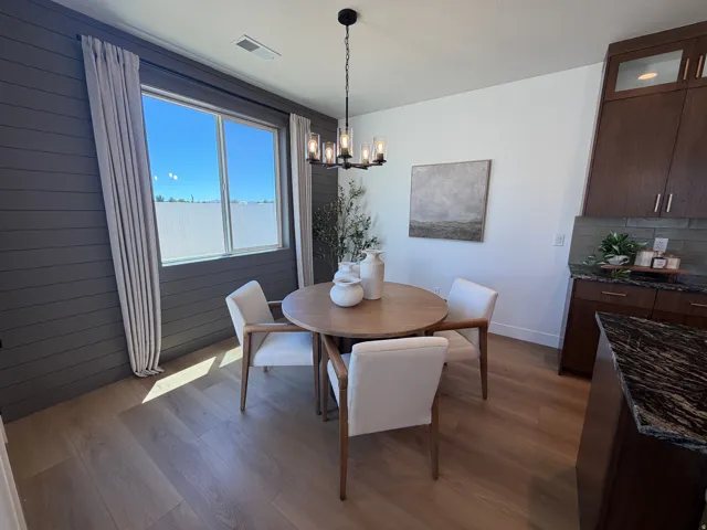 Dining area featuring wood-finish flooring and a contemporary chandelier