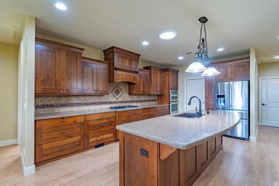 Kitchen featuring wood-finish cabinetry, light-toned countertops, and light wood-finish flooring