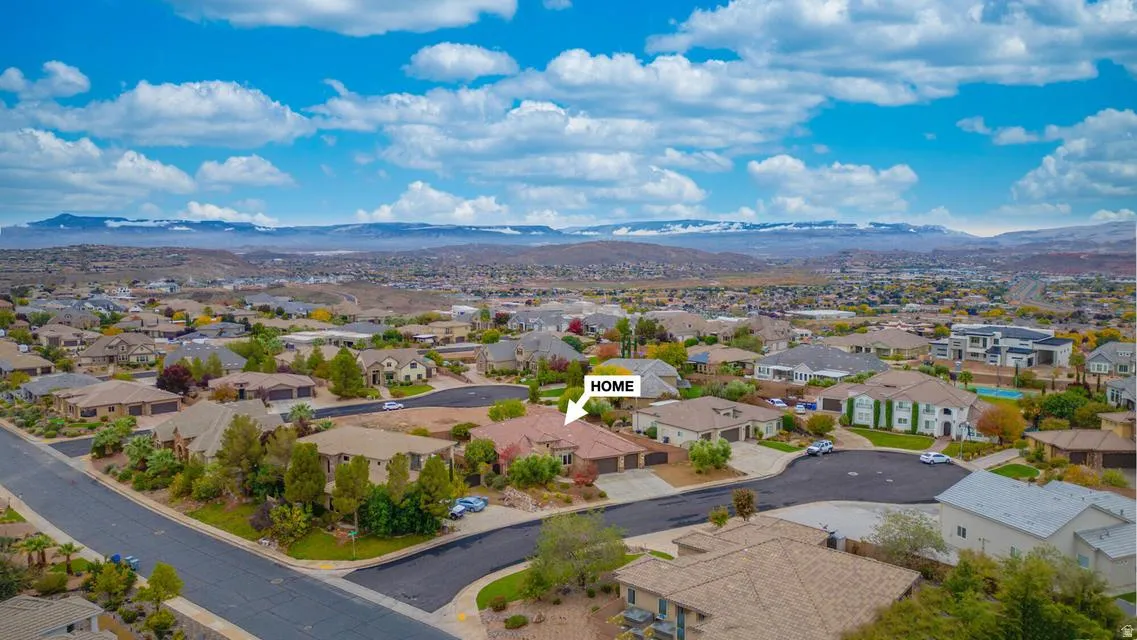 Aerial perspective showcasing a residential neighborhood with surrounding desert landscape and distant mountains