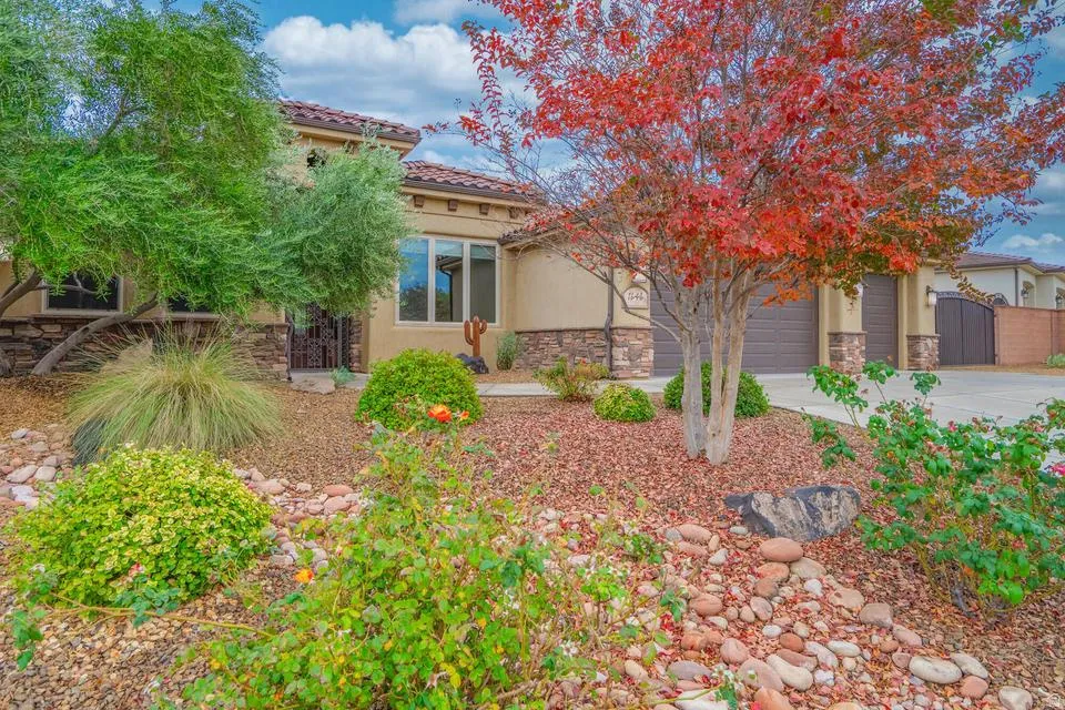 Southwestern-style stucco residence featuring a stone facade and red tile roofing