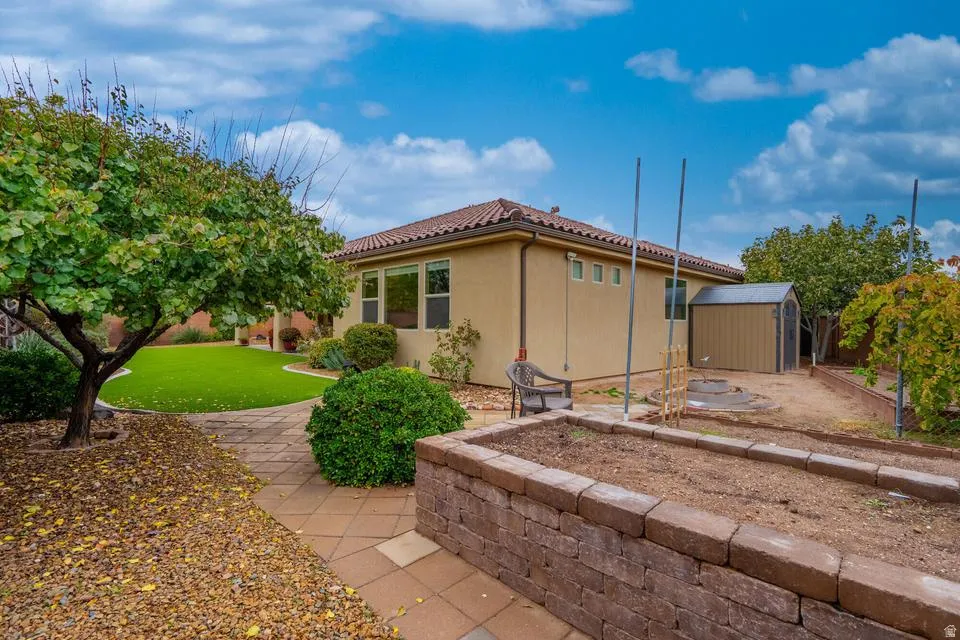 Rear exterior featuring a tiled roof and stucco finish