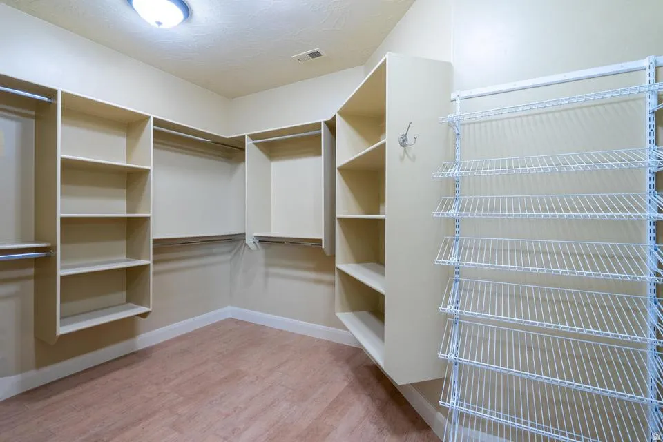 Walk-in closet featuring built-in shelving, hanging rods, and wire rack storage