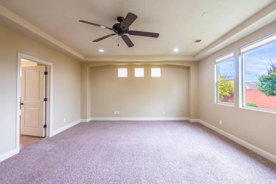 Spacious room featuring neutral carpeting, a ceiling fan, and recessed lighting