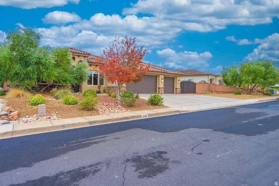Mediterranean-style residence featuring a stucco exterior, tile roof, and an attached two-car garage