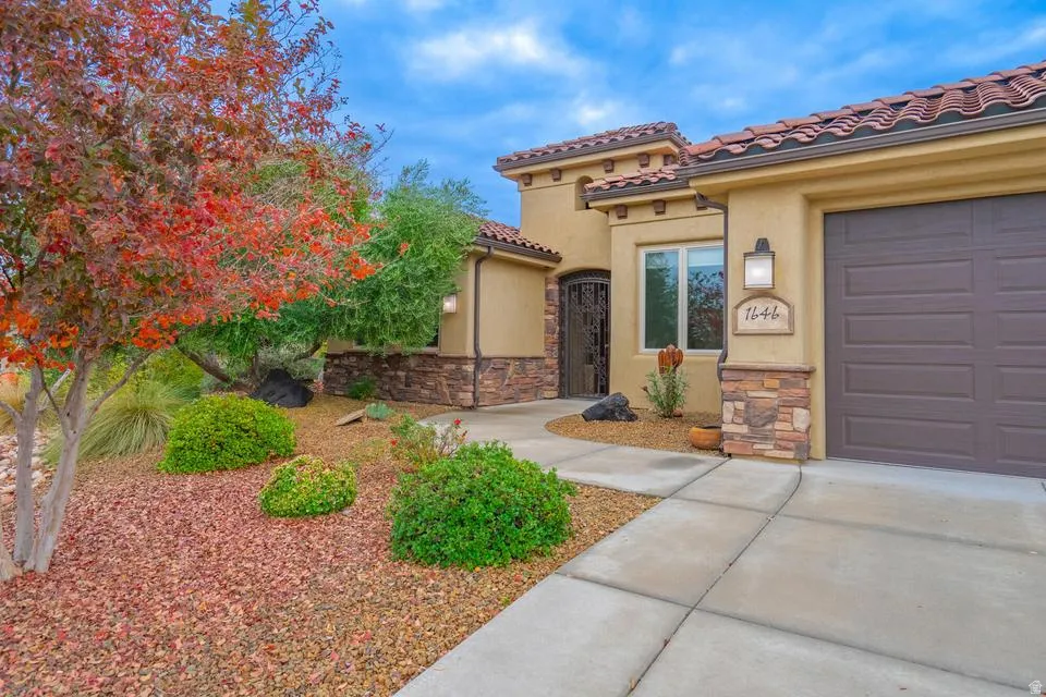 Stucco exterior with stone accents and a terracotta tile roof