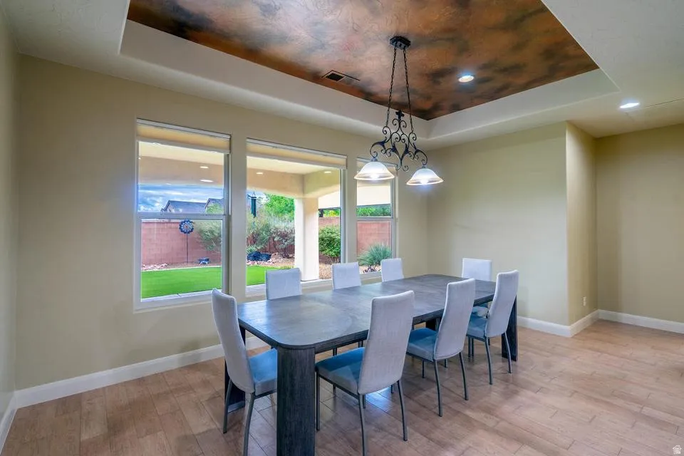 Dining space featuring a decorative tray ceiling with a wrought iron chandelier