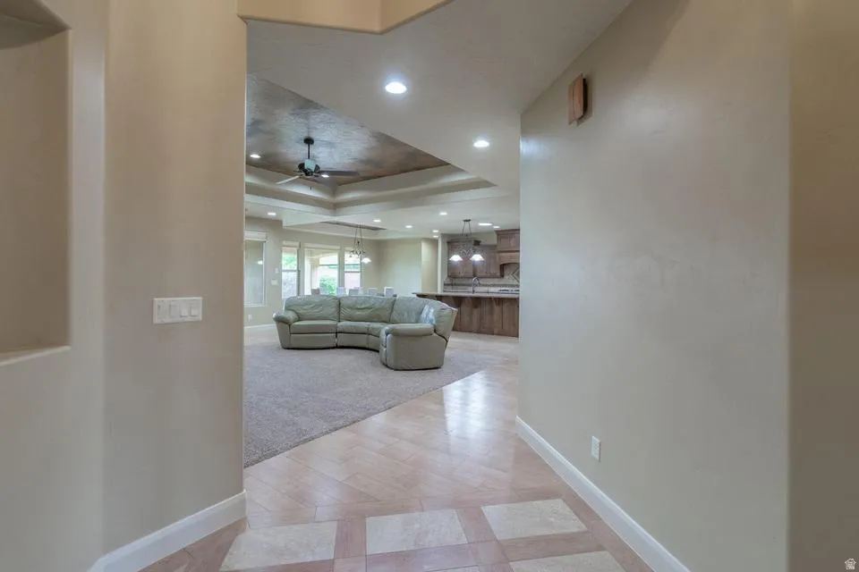 Travertine-style tile flooring with a patterned inlay opens to an expansive living area