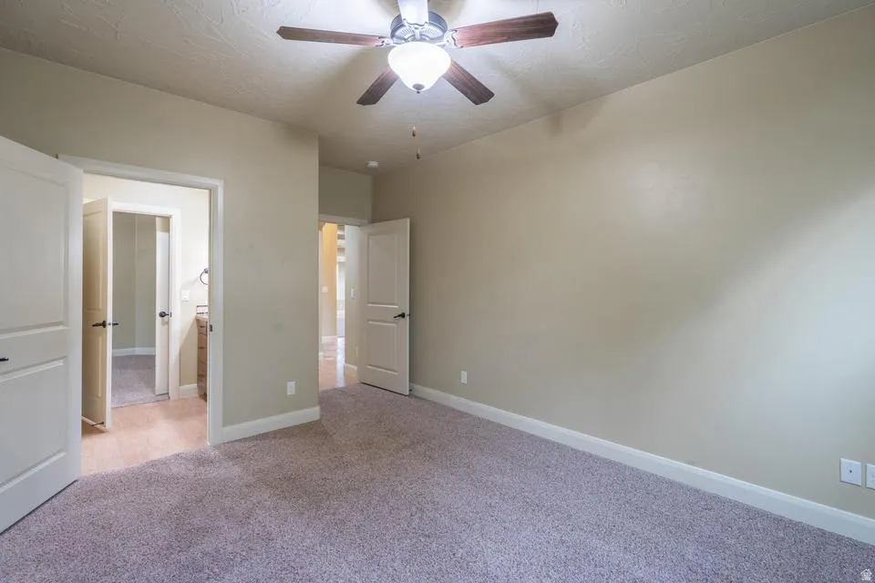 Spacious room featuring neutral carpet flooring and light beige wall paint