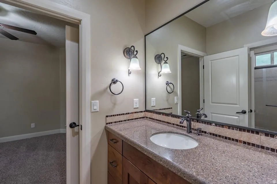 Bathroom vanity featuring a single undermount sink, speckled countertop, and wood-finish cabinetry