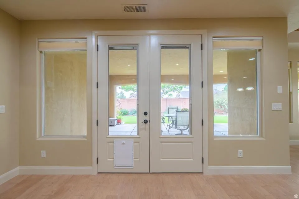 Double glass panel doors flanked by two full-length windows