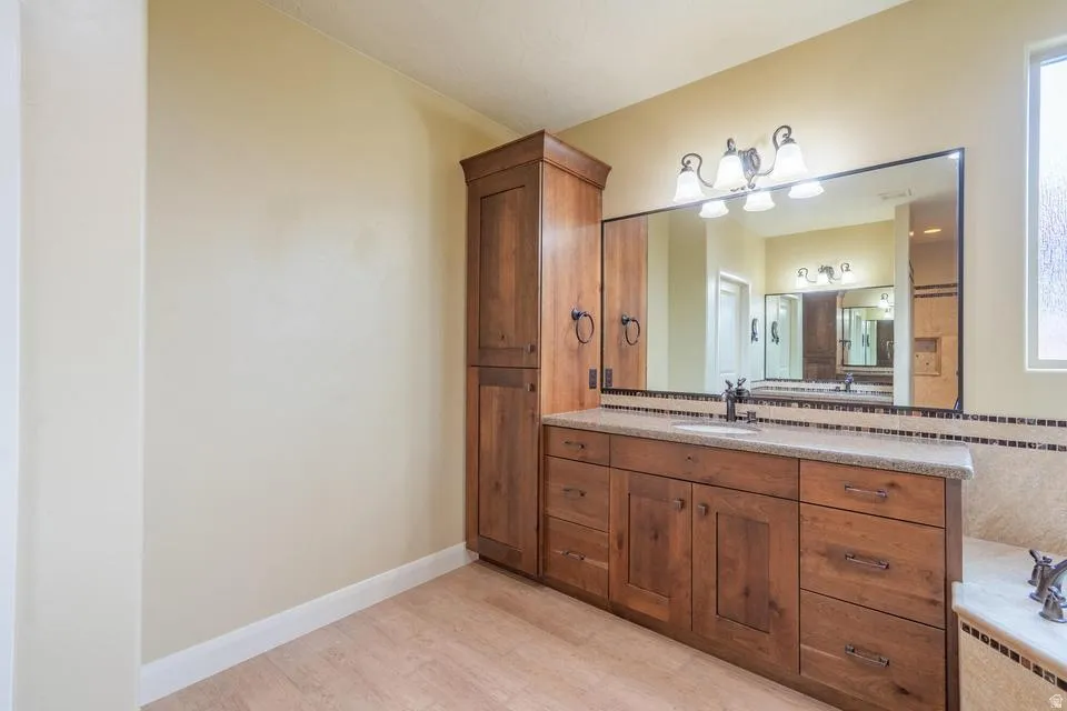 Warm wood cabinetry with a light stone countertop and an undermount sink