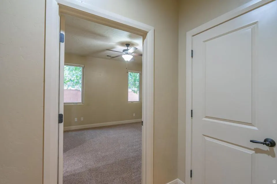 Interior space featuring neutral wall tones and a textured carpet