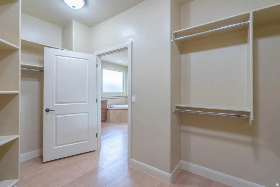 Walk-in closet featuring extensive built-in shelving and dual hanging rods
