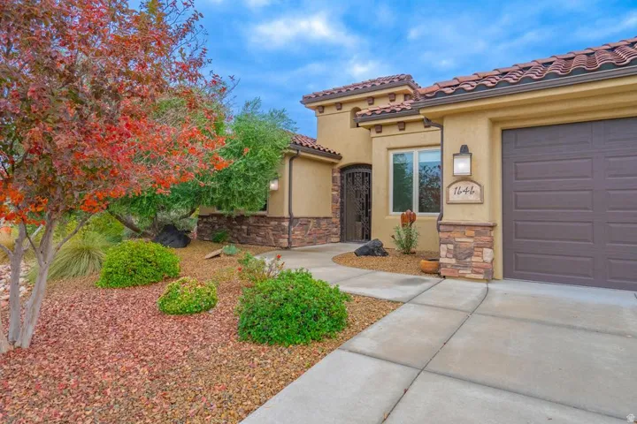 Stucco exterior with stone accents and a terracotta tile roof