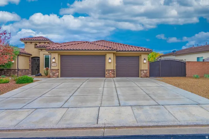 Stucco exterior with stone accents and a terracotta tile roof