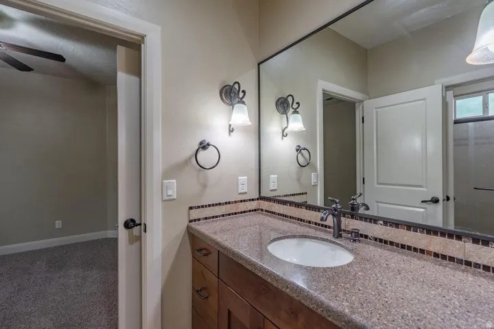 Bathroom vanity featuring a single undermount sink, speckled countertop, and wood-finish cabinetry