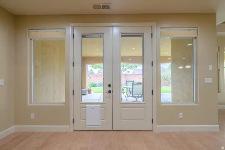 Double glass panel doors flanked by two full-length windows