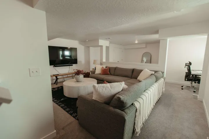 Spacious recreation room featuring carpet flooring and white painted walls