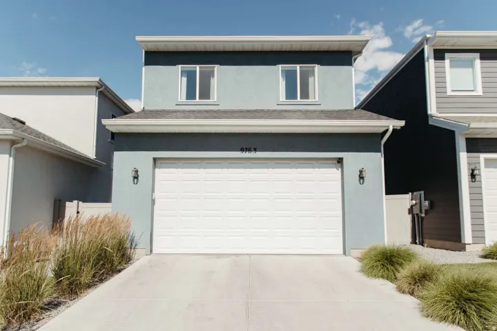 Contemporary two-story residence featuring a stucco exterior and a prominent two-car garage