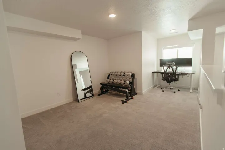 Carpeted room with recessed lighting and a window