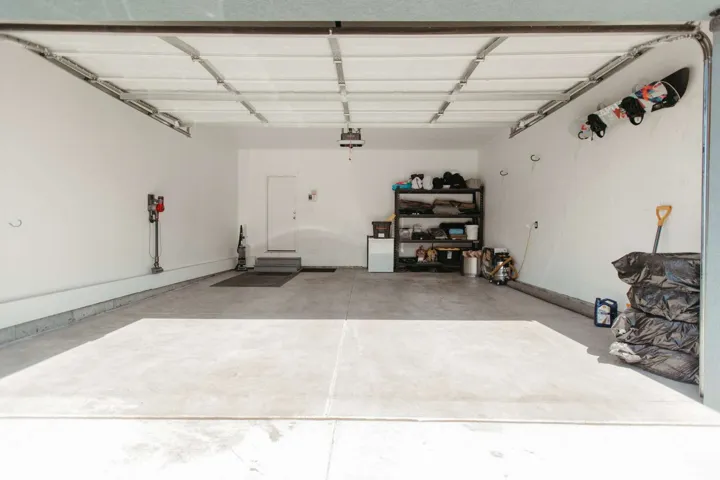 Spacious two-car garage with concrete flooring and bright white walls