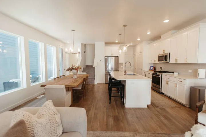 Open-concept living space with wood-finish flooring, white walls, and recessed lighting
