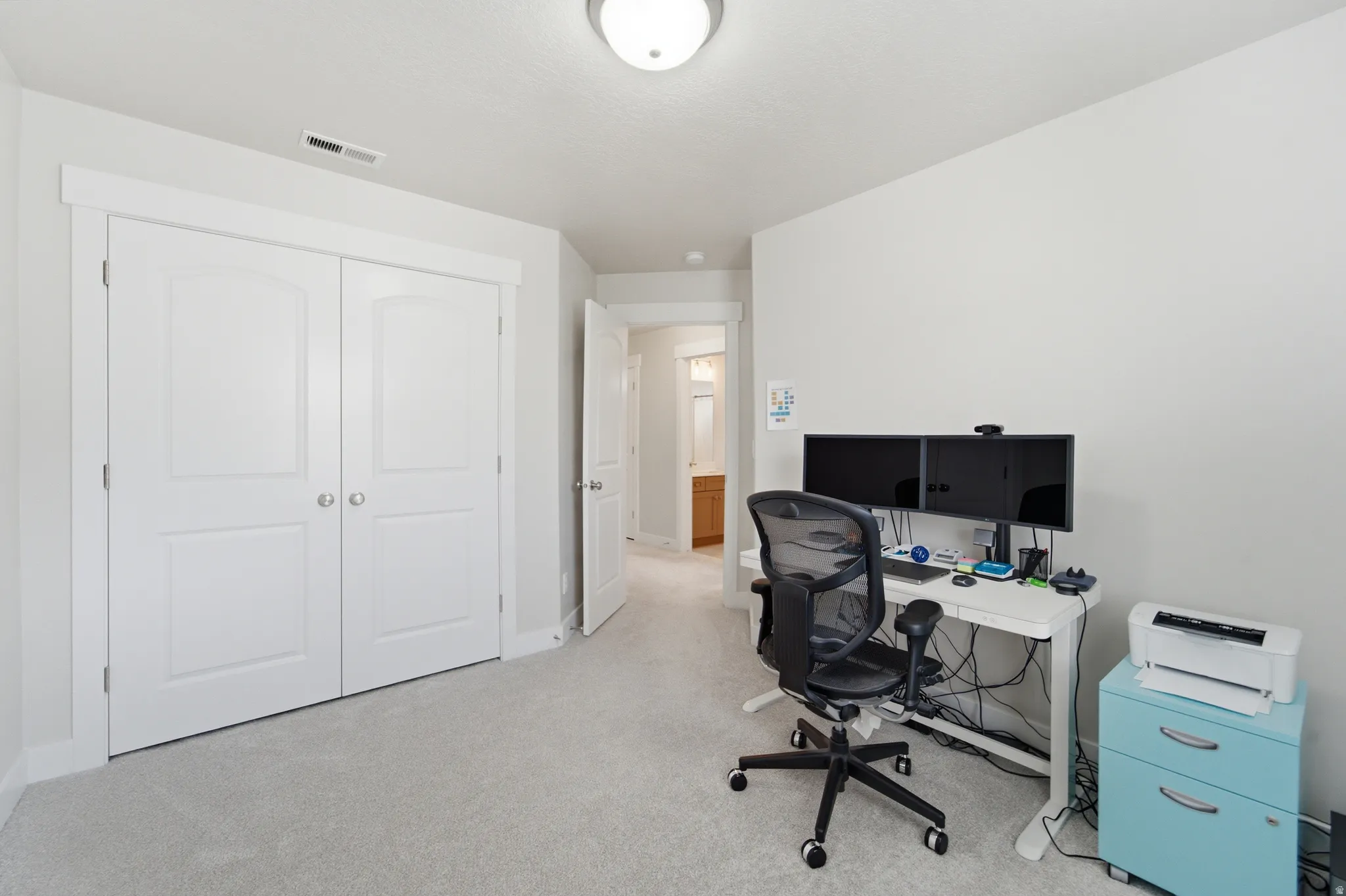 Bedroom featuring light gray carpeting, white walls, and a ceiling light fixture