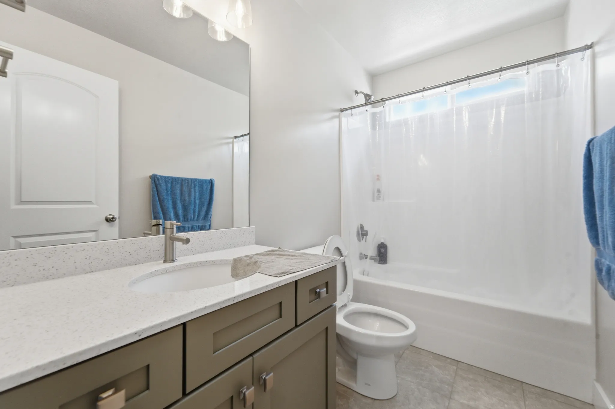 Bathroom featuring a vanity with a light-toned countertop, undermount sink, and brushed nickel faucet