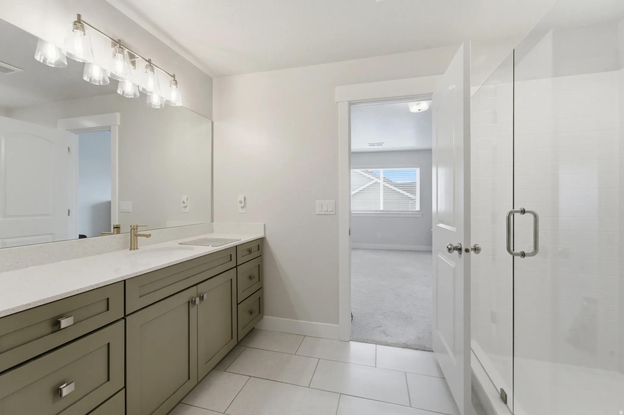 Upgraded green cabinetry, white countertops, tile flooring, and a single basin sink
