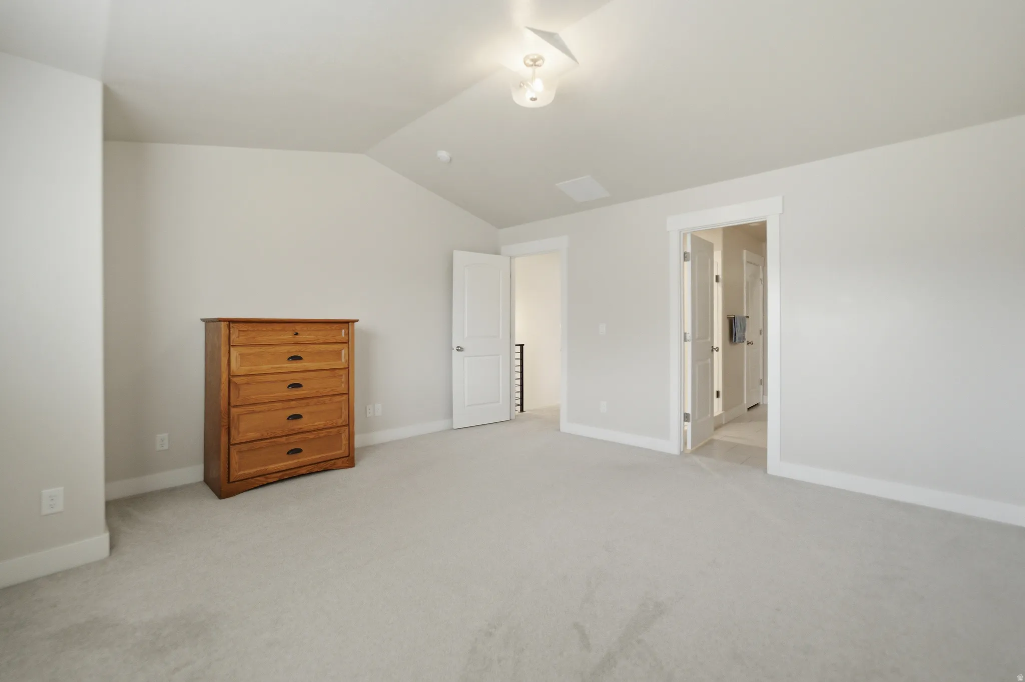 Neutral-toned carpeting extends throughout this room, featuring light gray walls and white trim